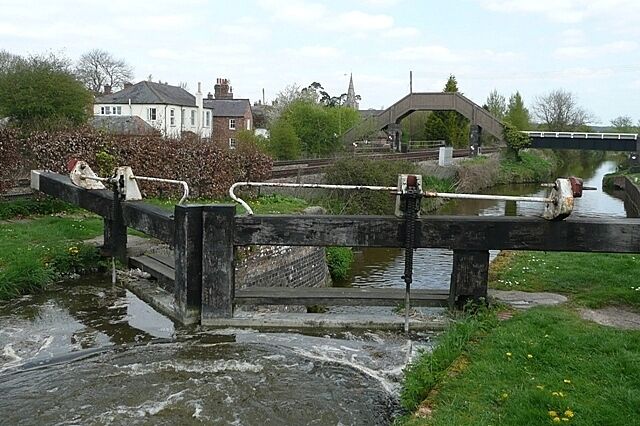 Little Bedwyn Lock Little Bedwyn is one of the classic places on the canal for photographs, showing some combination of the railway, the canal, the church, the lock and the footbridge. It also happens to be on the border of two grid squares. I was waiting for a train to come as we worked the lock, but as you can see from the wash our boat is leaving and I'm meant to be on board.