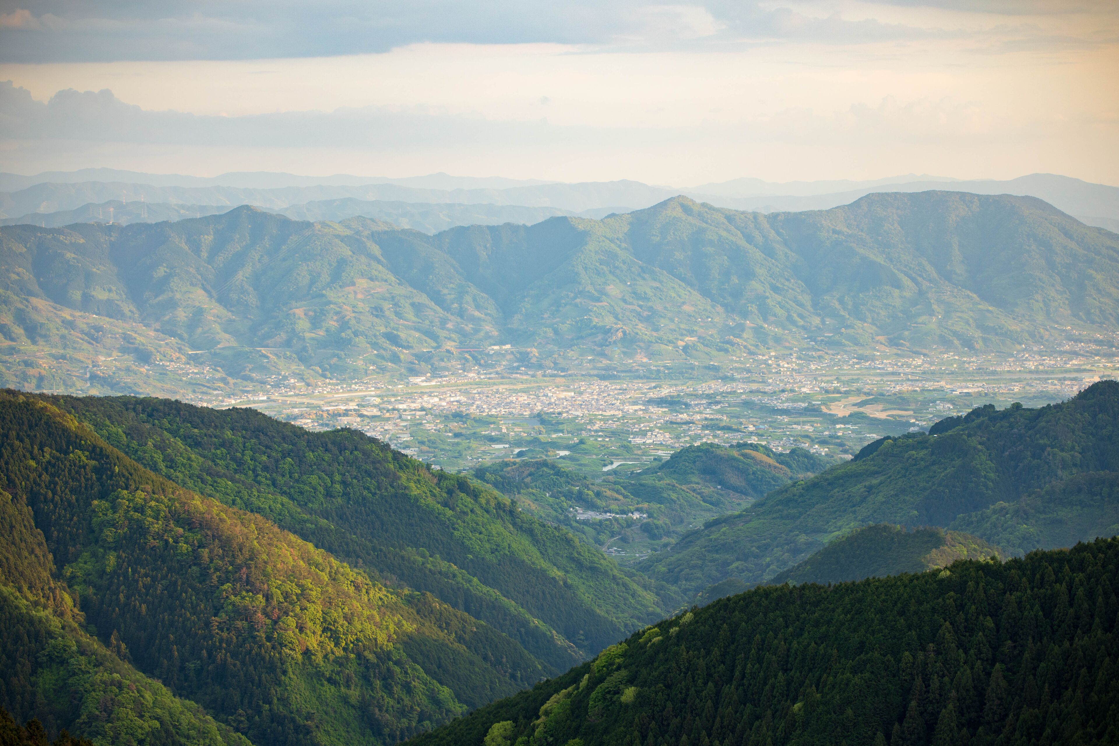 Small town nestled in valley between rugged green mountains