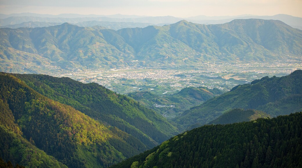 Small town nestled in valley between rugged green mountains