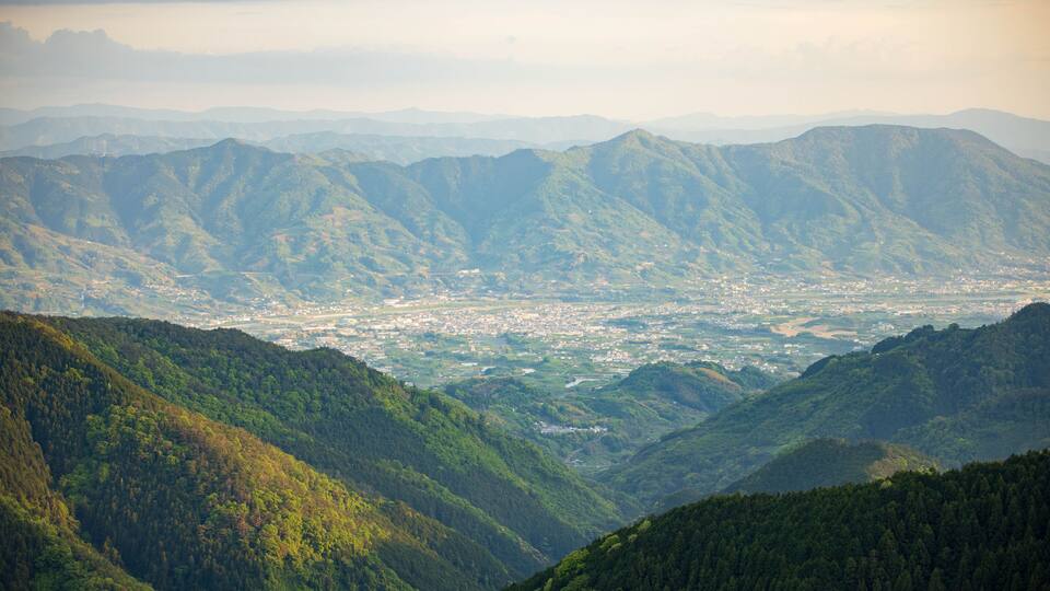 A mountainous landscape with a valley and a town.