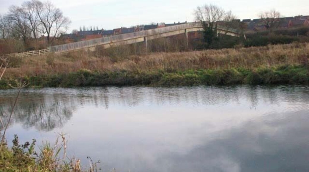 Footbridge below Higham Ferrers. The footbridge carries Kings Meadow Lane over the A45 bypass, giving access to the riverside paths, old gravel pits and the footpath to Irthlingborough. The River Nene (pronounced 'Nen' hereabouts) is in the foreground.