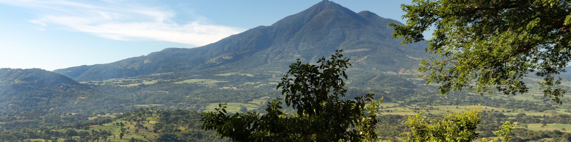 Un paisaje montañoso con abundante vegetación y cielo despejado.