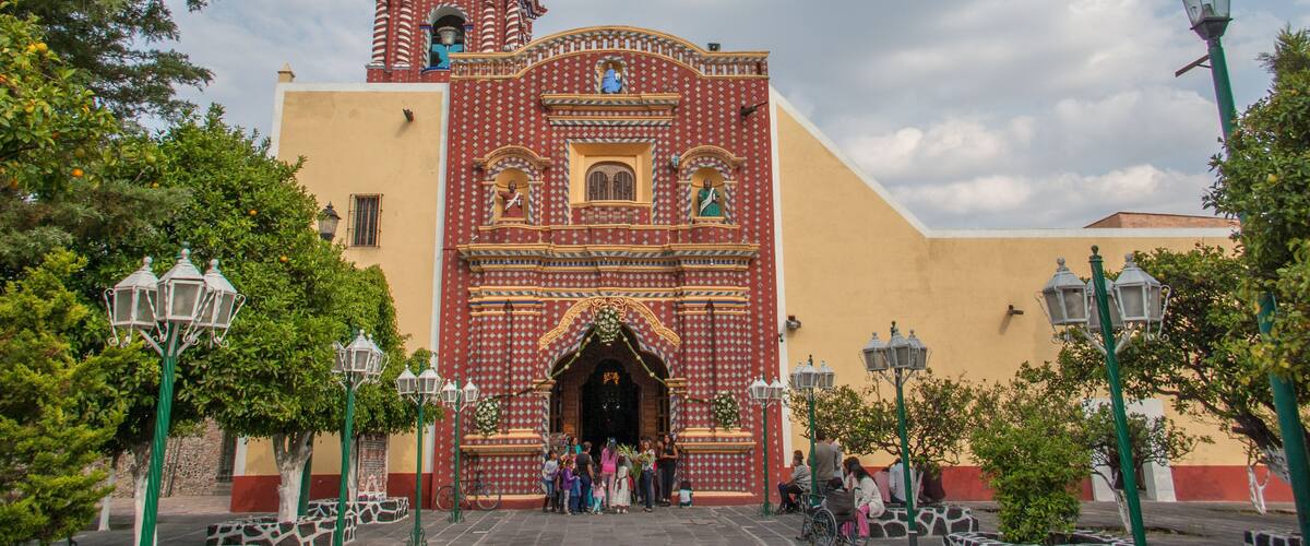 A colorful church with a bell tower and ornate decorations.