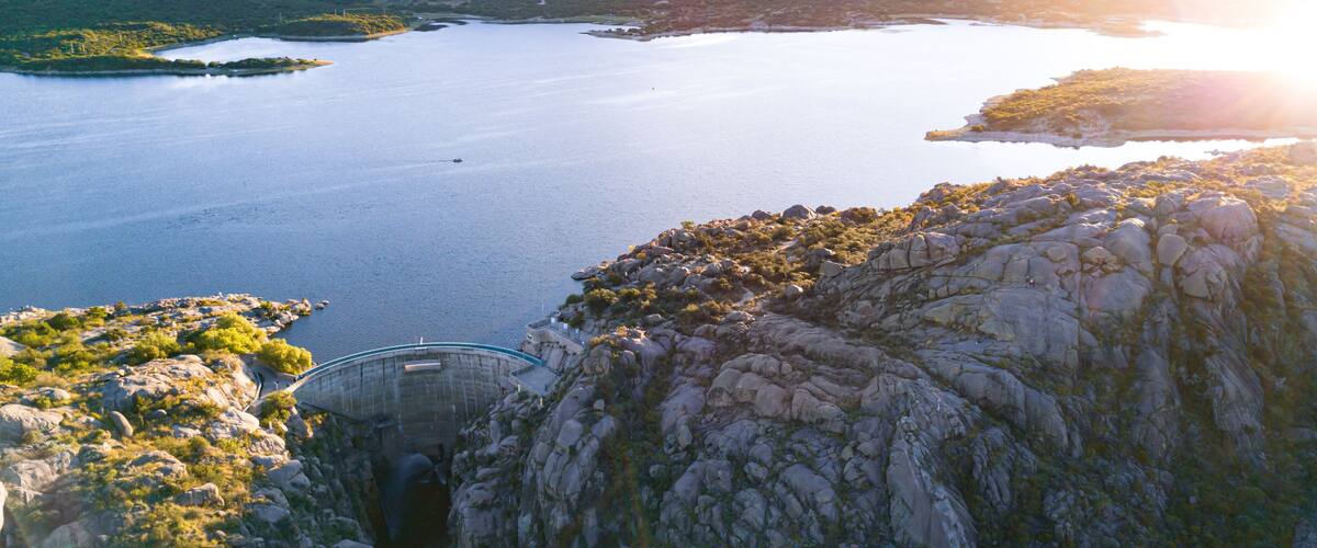 A large body of water surrounded by rocky terrain and hills.