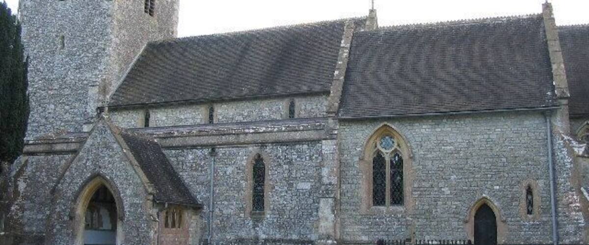 A stone church with a tower and arched windows.