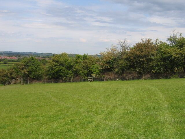 Heart of England Way. Looking along the path around the lower slopes of Meon Hill as it approaches a stile near the edge of the square.