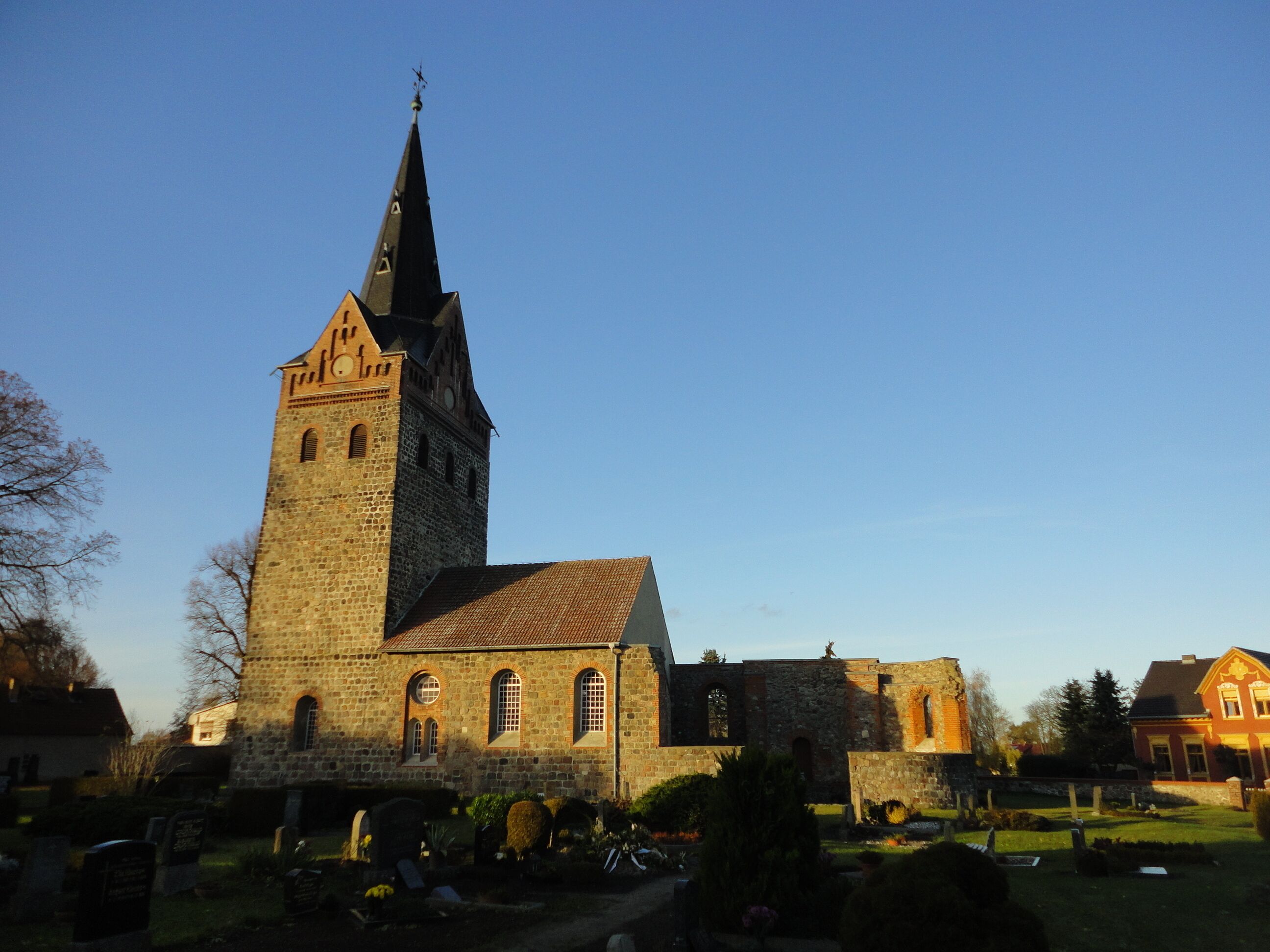 A historic church with a tall tower and a smaller adjacent building.