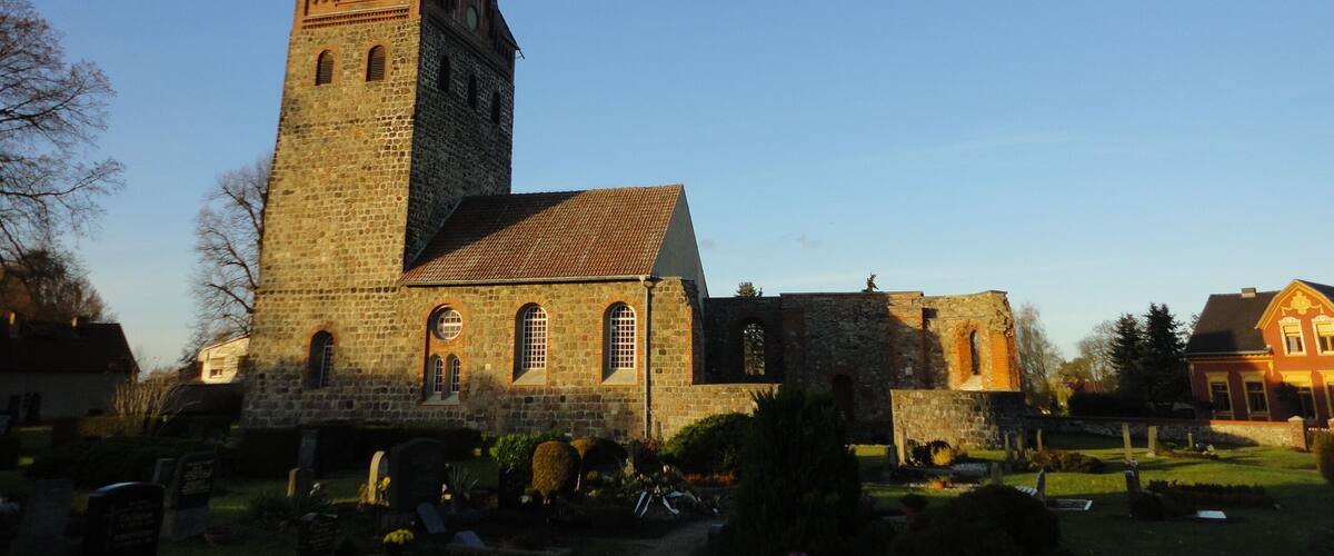 A historic church with a tall tower and a smaller adjacent building.