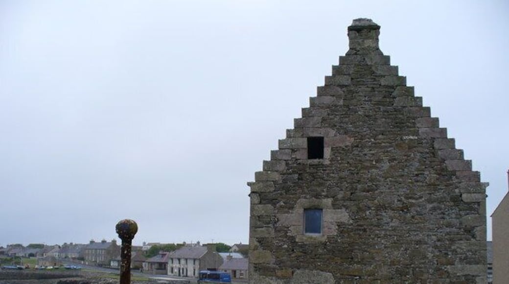 The Old Granary, St Mary's, Orkney: an old red sandstone building with stepped gable between the main road through the village and the shore