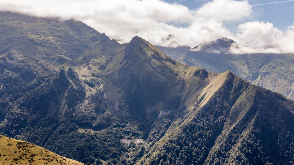 A mountain range with dense forests and a valley.