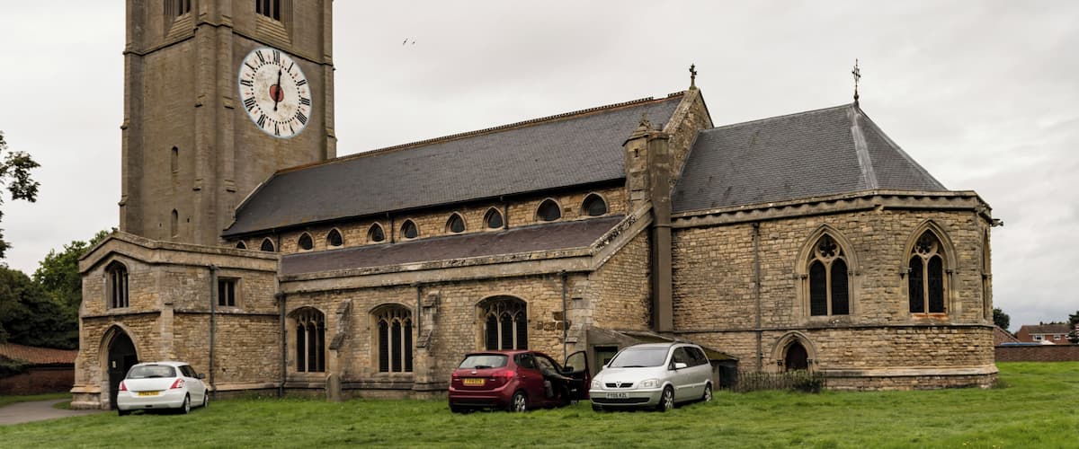 A historic church with a tall clock tower and a steeple.