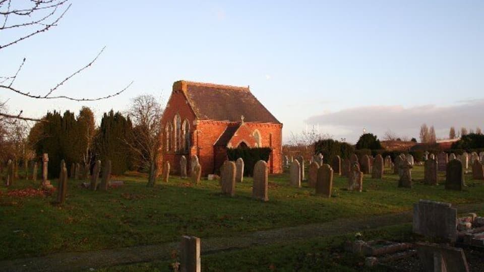 A church surrounded by a cemetery with gravestones.