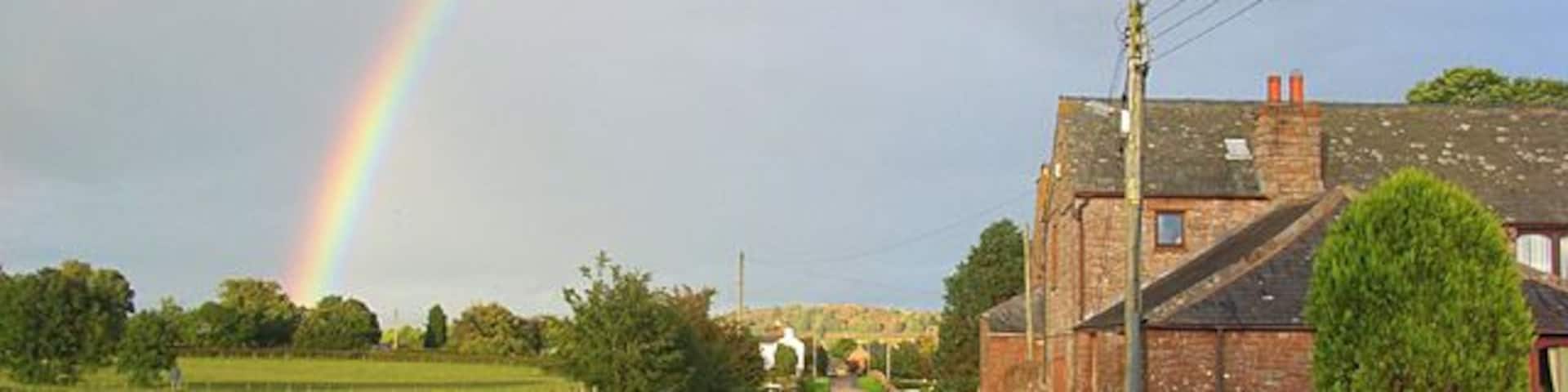 Road and house at Catterlen Just above the junction with the B5305 beyond which further houses can be seen.