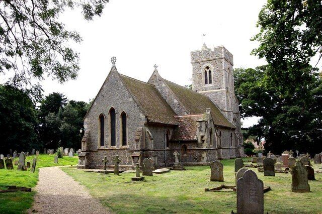 A historic church with a prominent tower and a graveyard with headstones.