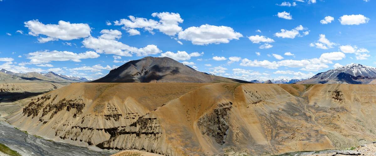 A river winding through a rugged, mountainous landscape with a prominent peak in the background.