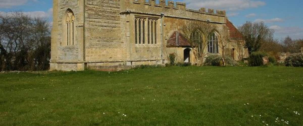 A historic stone church with a tower and arched windows.