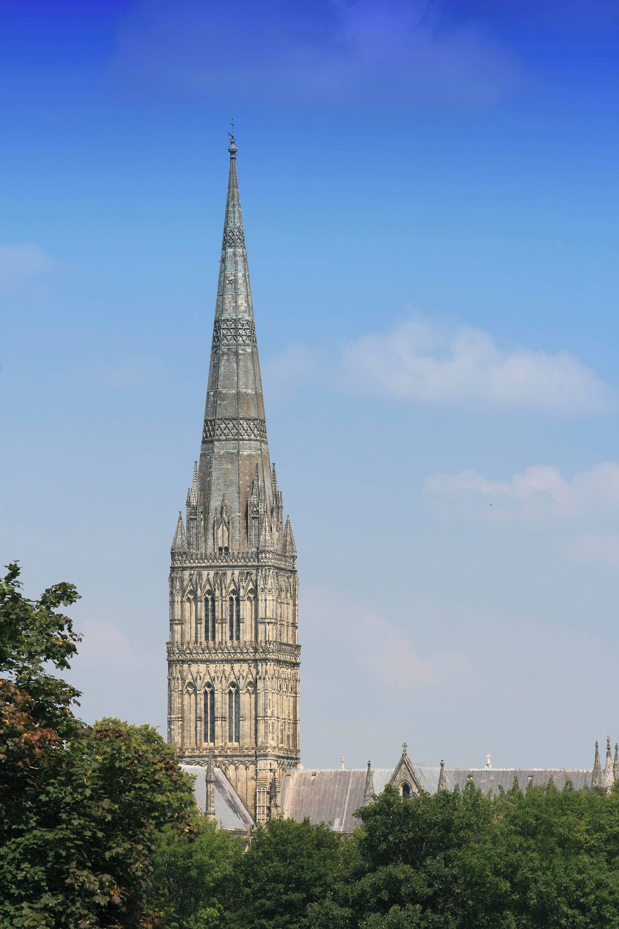 A tall, Gothic-style church tower with intricate stone carvings and a pointed spire.
