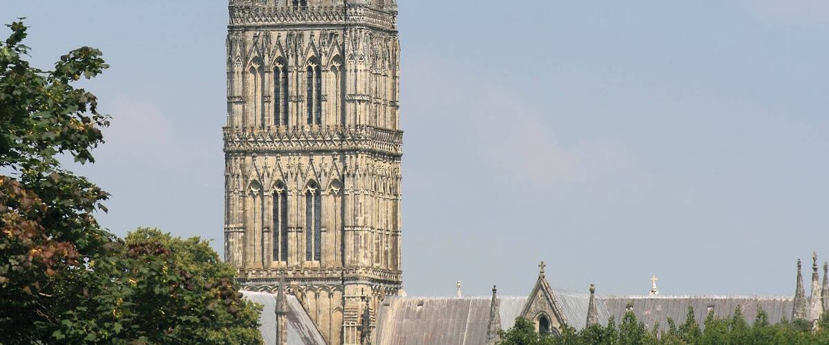 A tall, Gothic-style church tower with intricate stone carvings and a pointed spire.