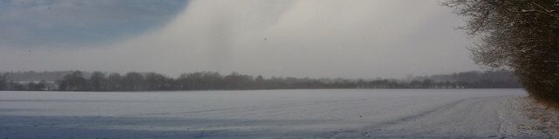 Field and clearing snow shower clouds Seen from a gateway on the Thornham estate, with no public access beyond into the field itself.