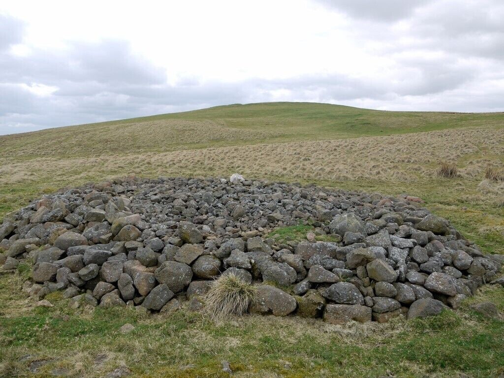 Bronze Age burial cairn north-east of Wether Law View south-west to the hill-fort. Excavation in 1997 revealed a round cairn surrounded by a low stone wall. The cairn was thought to be of Bronze Age type but no burial traces or pits were found. The cairn had been opened by a robber trench in the medieval period http://ads.ahds.ac.uk/catalogue/search/fr.cfm?rcn=NSMR03-3227 Fairly close to the cairn, excavation between 1994 and 2003 found evidence for timber buildings dated to the middle or late Iron Age. A timber-lined coffin, discovered by chance contained the remains of at least five Bronze Age pots, one of which has been reconstructed and on display at the Ingram National Park Centre http://ads.ahds.ac.uk/catalogue/collections/nsmr03abstracts/3226.html
