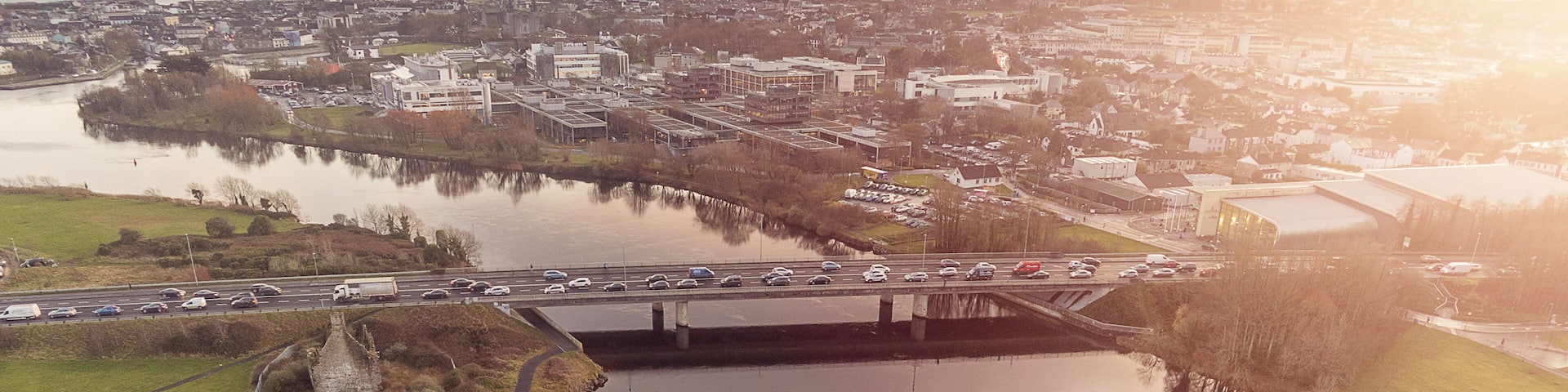 Aerial view on Galway city. Road N6 and bridge over Corrib river, Terryland castle remains, Sun flare, Ireland.