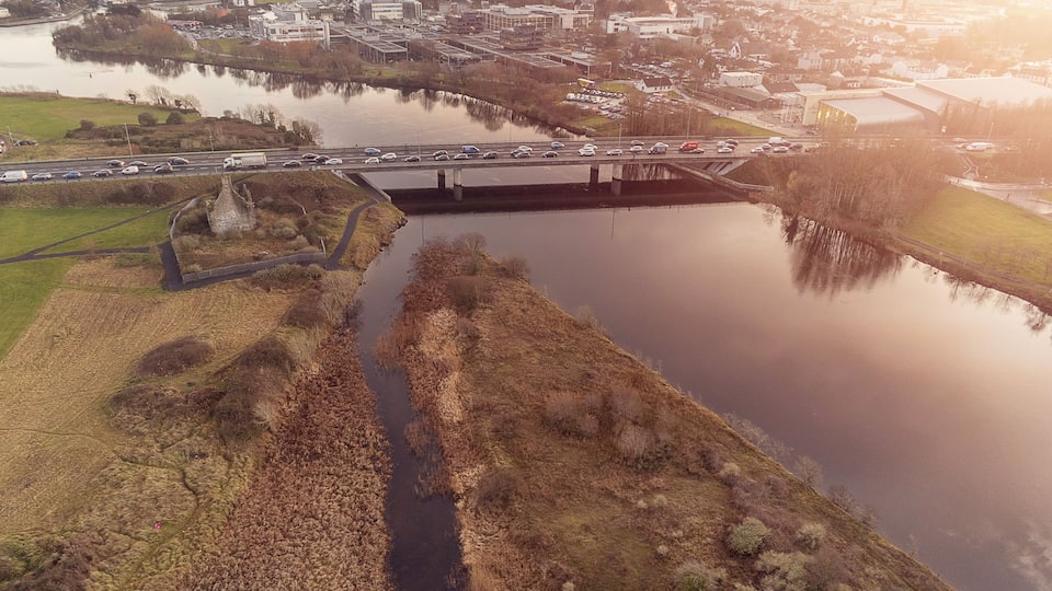Aerial view on Galway city. Road N6 and bridge over Corrib river, Terryland castle remains, Sun flare, Ireland.