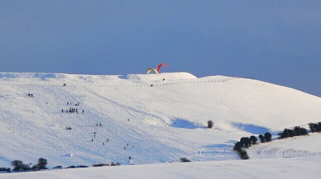 Gliders and sliders, Liddington Castle As ever when the wind is in the north, paragliders take to the air from the castle at the western end of Liddington Hill. This time they are accompanied by people sliding down the slope.