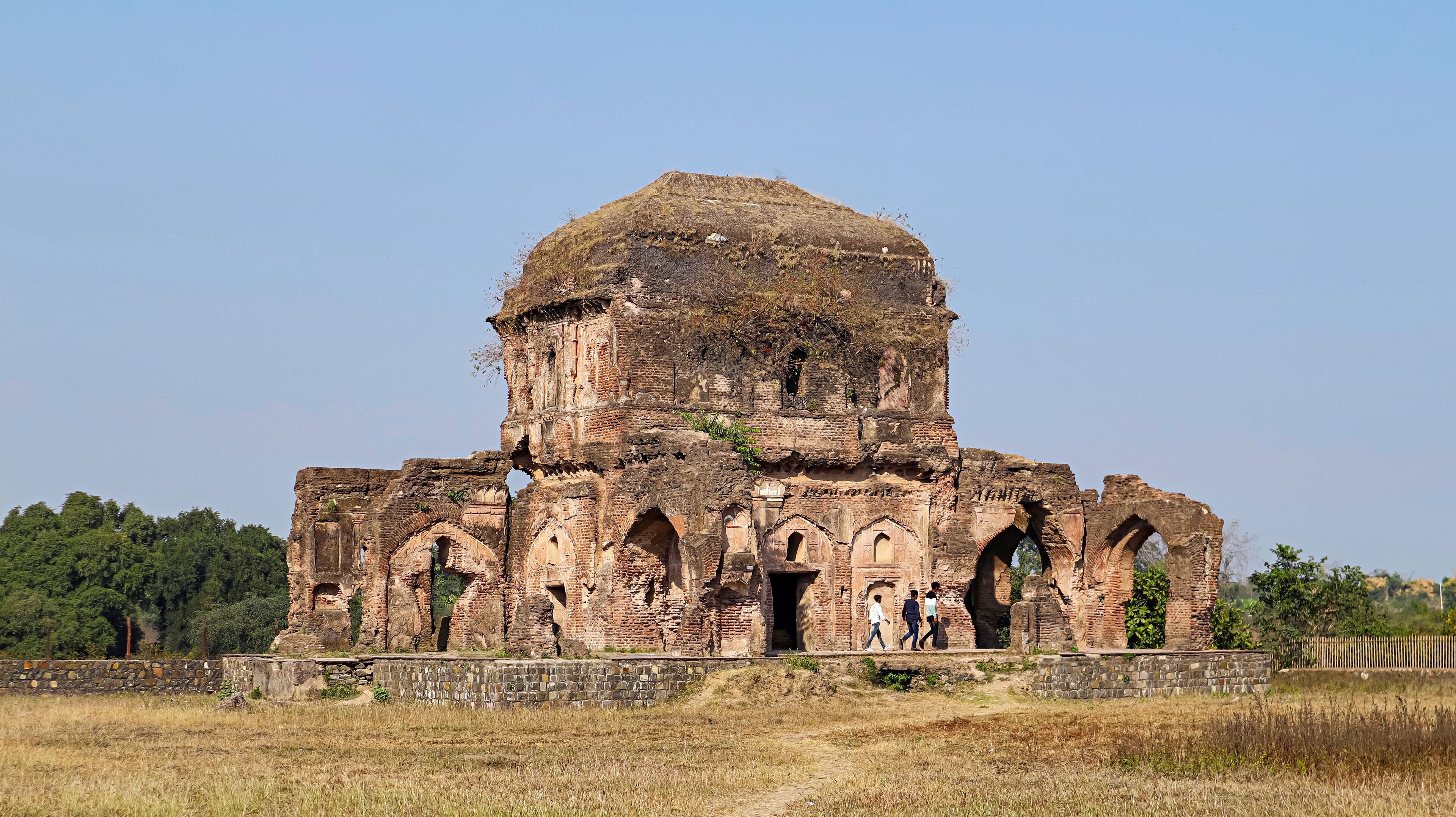 An ancient brick structure with a dome and arched openings.