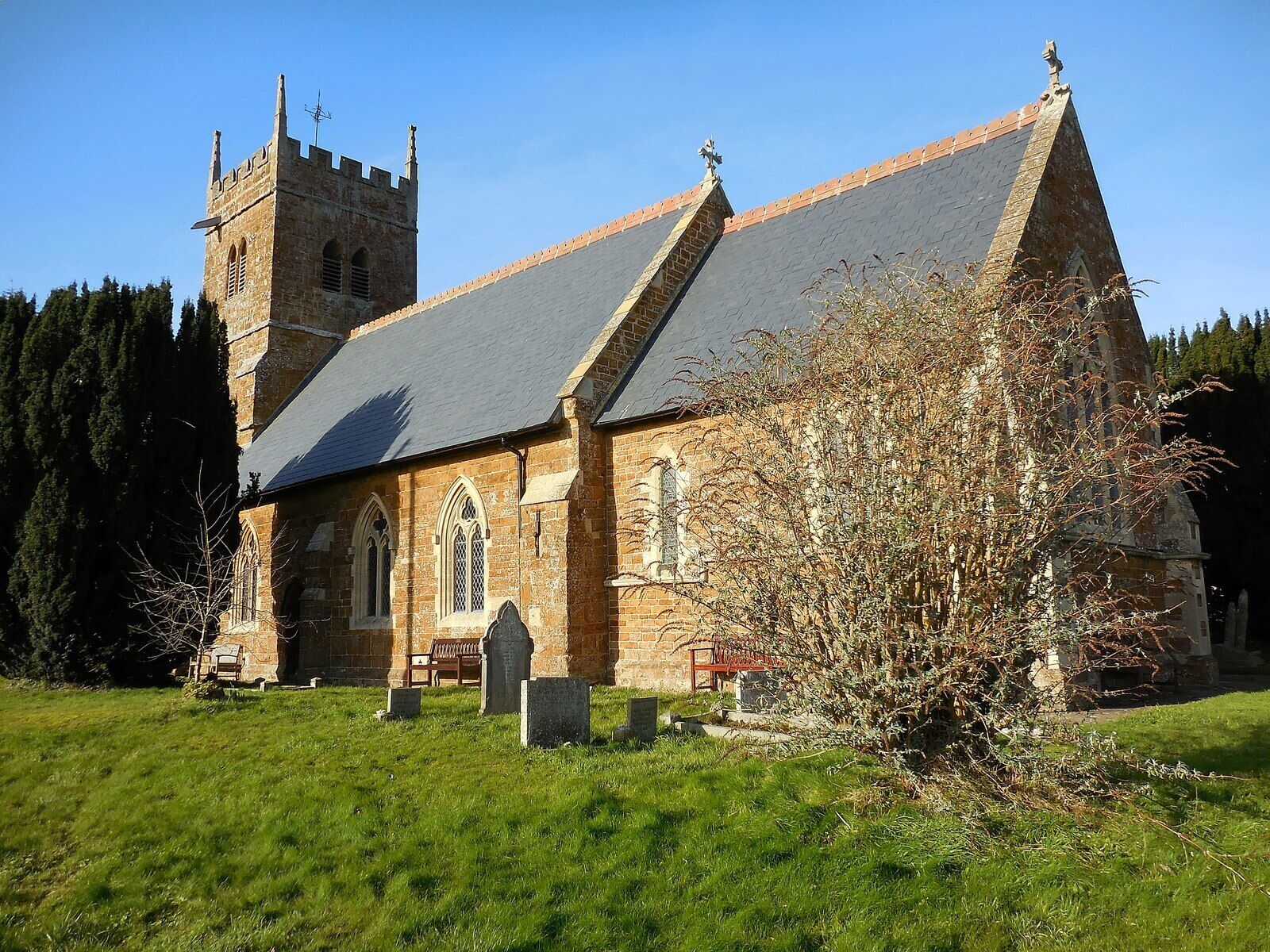 A church with a tall tower and a steeply pitched roof.