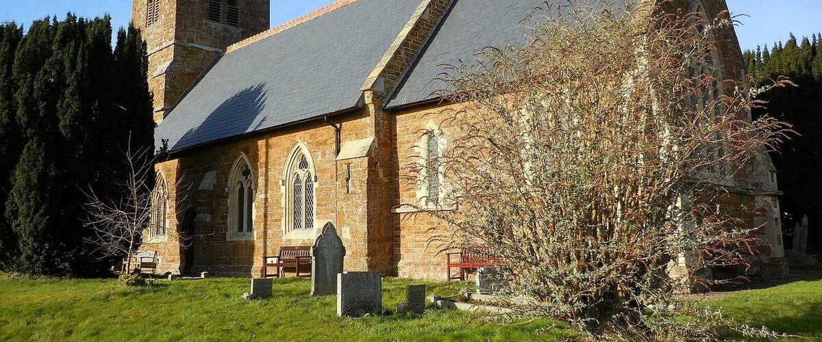 A church with a tall tower and a steeply pitched roof.