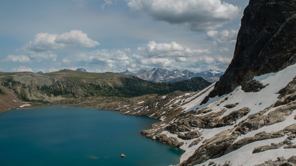A mountain lake surrounded by rocky terrain and snow-covered peaks.