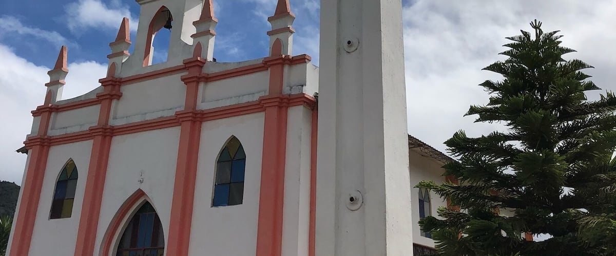 A church with a large white cross in front.