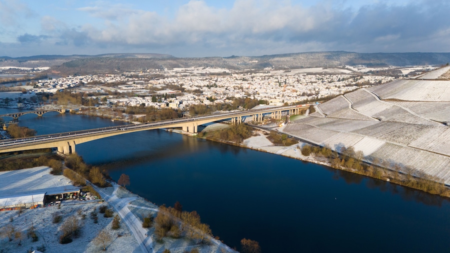 Snow covered Moselle valley, vineyard and Mosel river, Viaduct Longuich bridge of highway crossing near Trier, aerial view, winter season with frost in Germany