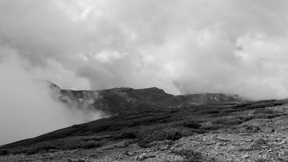 A rugged mountain landscape with a misty atmosphere.