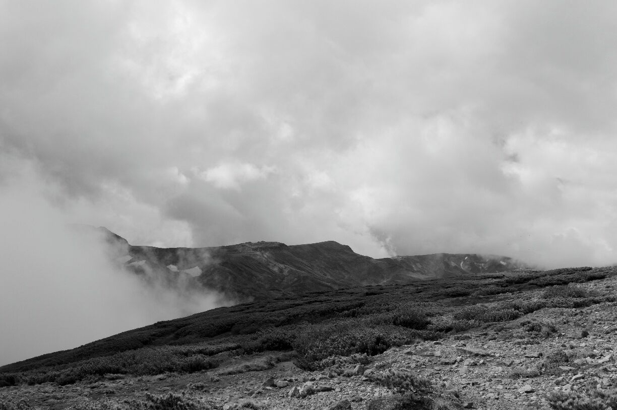 A rugged mountain landscape with a misty atmosphere.