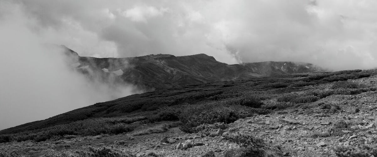 A rugged mountain landscape with a misty atmosphere.