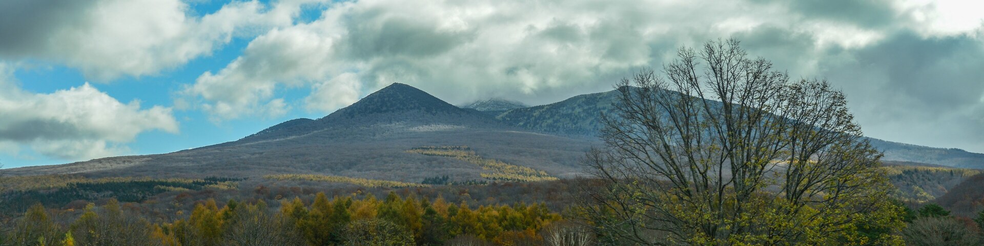 A mountain landscape with autumn foliage and a clear sky.