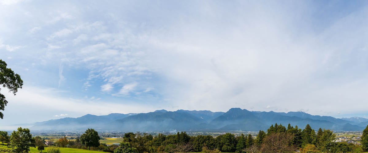 Un paisaje montañoso con un pueblo en el valle.