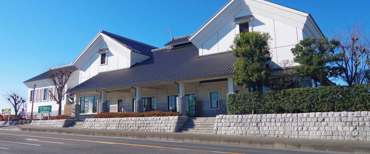 A modern two-story house with a stone wall and a blue roof.