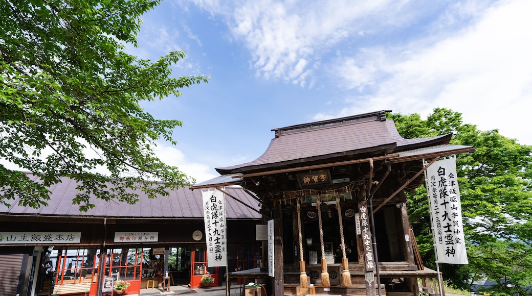 A traditional Japanese shrine with a wooden structure, surrounded by lush greenery.