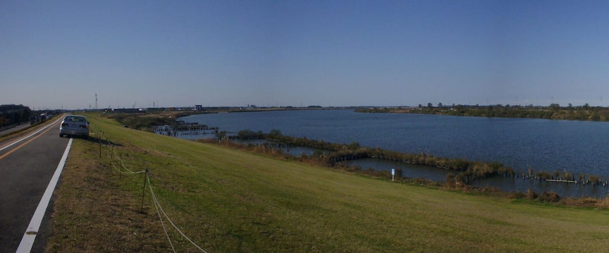 A large body of water with a road curving alongside it.