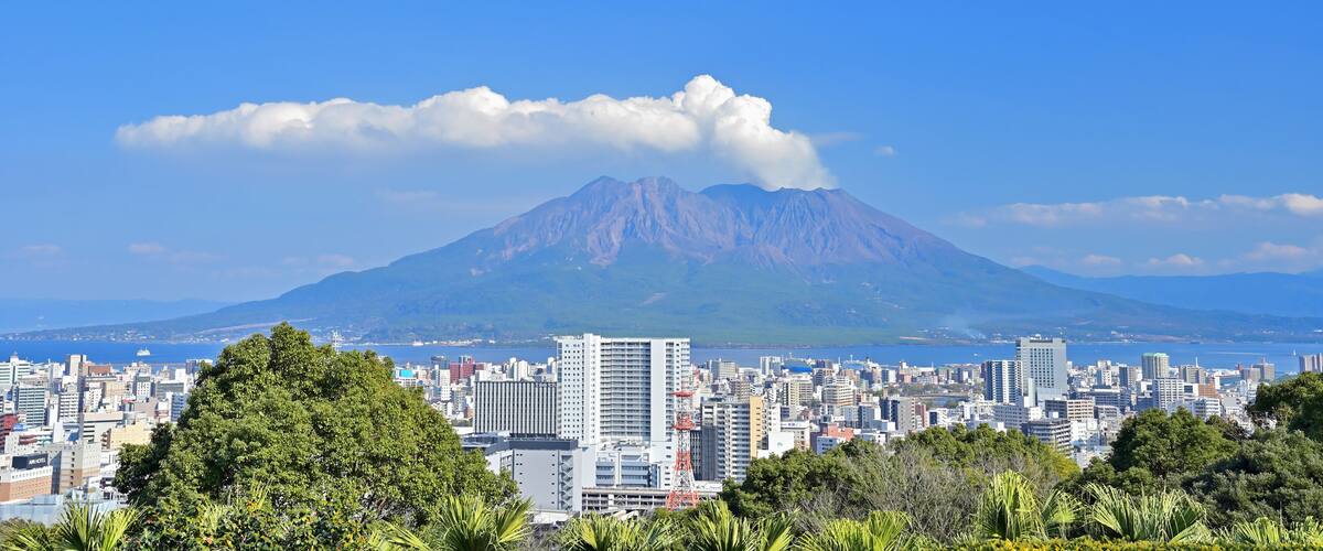 A cityscape with a prominent mountain in the background.