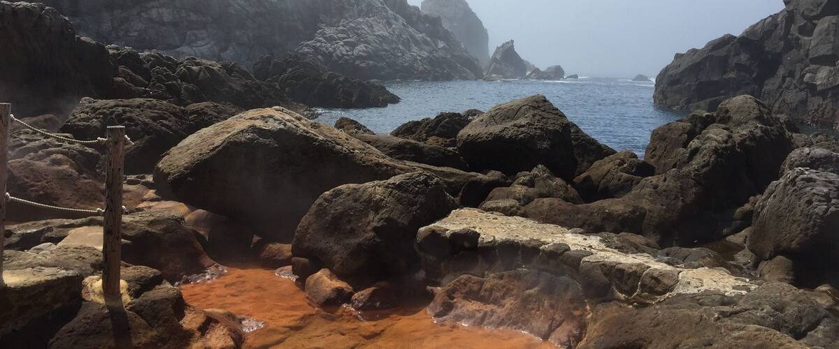 A rocky coastal landscape with a clear sky.