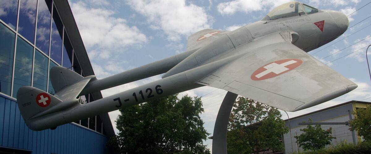 A vintage aircraft with a red cross emblem and the number J-1126, displayed outdoors.