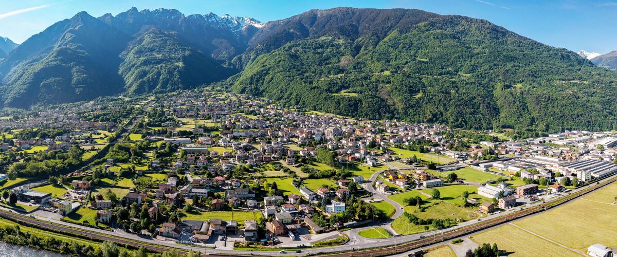 A town nestled in a valley with mountains in the background.