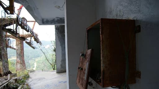 An abandoned cable car at the top of the mountain. A completely deserted playground of overgrown temples and statues