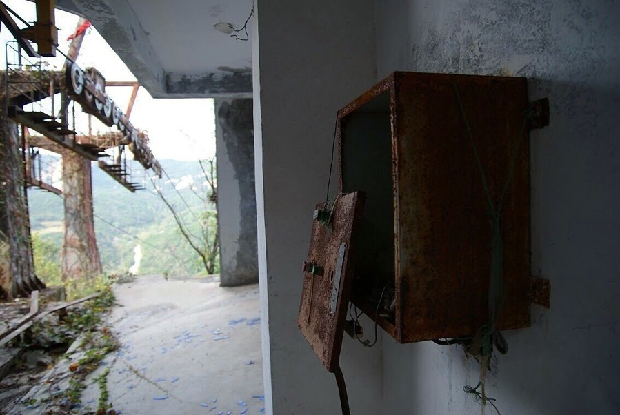 An abandoned cable car at the top of the mountain. A completely deserted playground of overgrown temples and statues