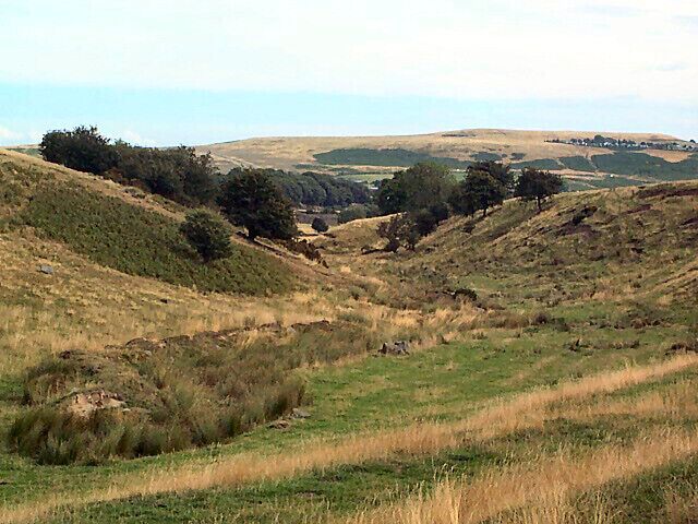 Valley of Loadpit Beck. This small valley carrying the infant Loadpit Beck runs eastwards from Heights Lane and eventually becomes Shipley Glen. It marks the southern boundary of the gridsquare. The caravan park on Baildon Moor is seen in the far distance on the right.
