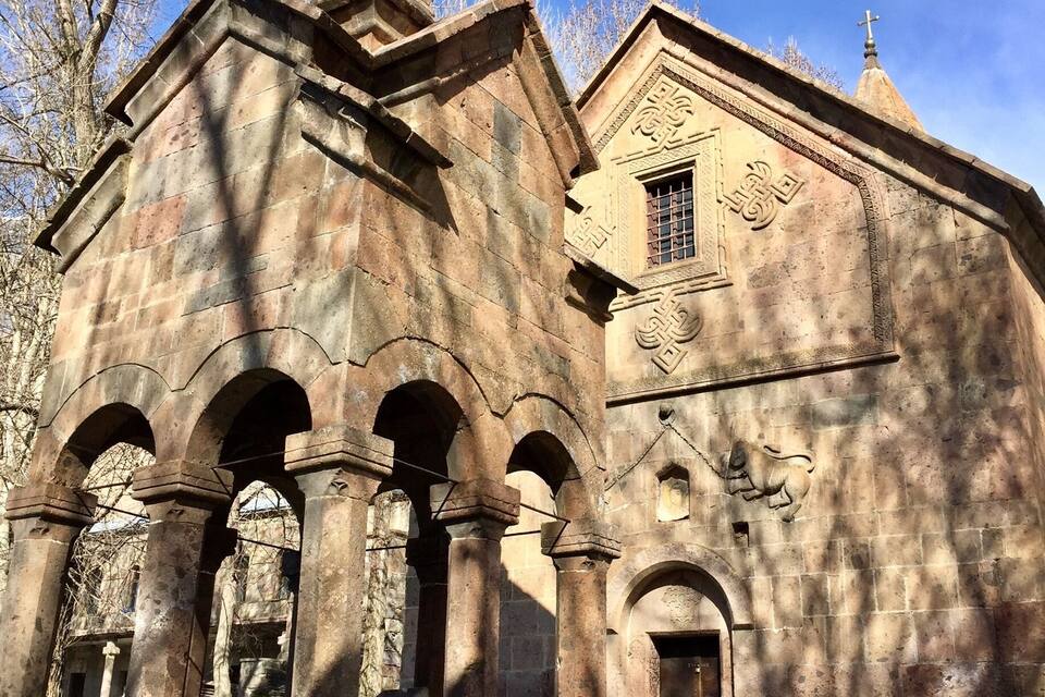 Una església històrica amb un campanar, finestres d'arc i una creu al teulat.