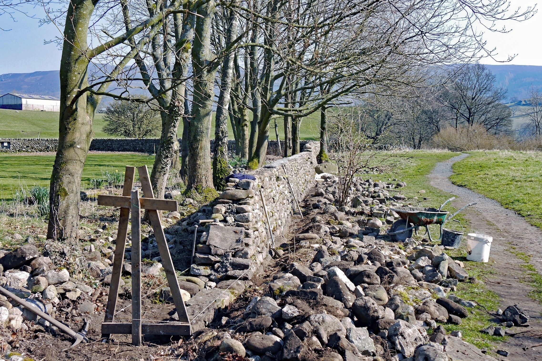 Dry-stone walls are an integral feature of the Yorkshire Dales.  Whilst you will often see them being repaired it is more unusual to see a new one being built.
Here at Appletreewick I was fortunate to see a craftsman building this wall.  I could only admire his skill.  Whilst he finished the wall with a mortared coping, the wall itself is "dry".